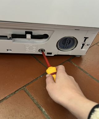 Adjusting levelling bolts on a washing machine
