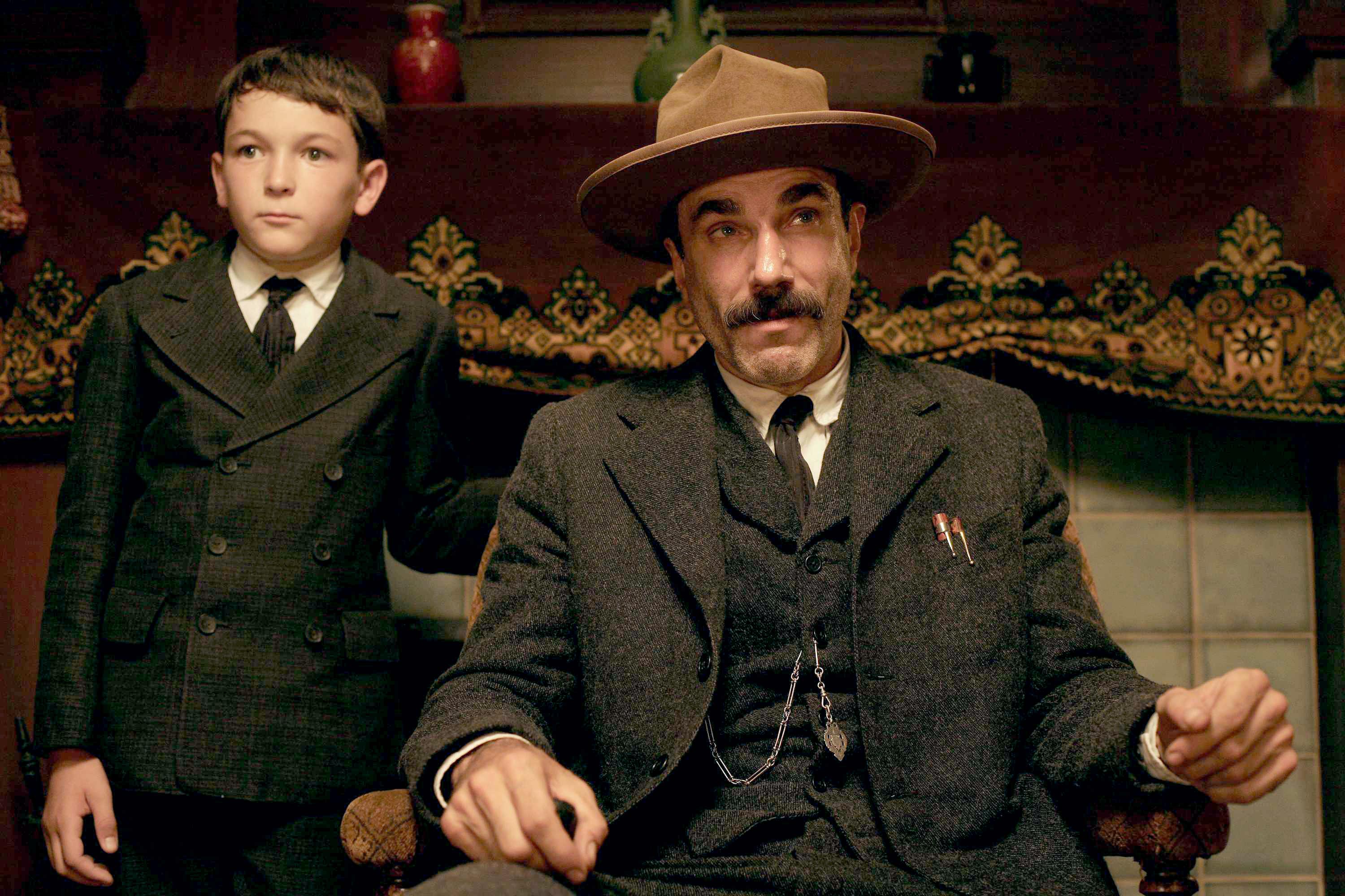 Dillon Freasier as HW Plainview and Daniel Day-Lewis as Daniel Plainview in a conversation with someone else in There Will Be Blood