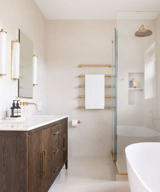 A neutral colored bathroom with a glass standing shower, a rounded white bathtub, and a brown wooden standing sink unit.