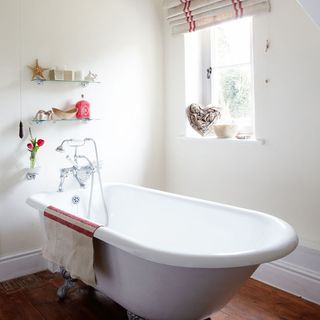 bathroom with bathtub and white wall and wooden floor