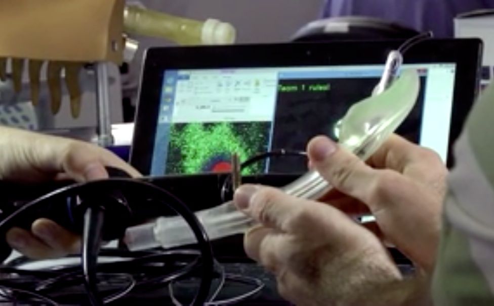 A researcher holds the GuideIn Tube, a self-guided robotic intubation device.