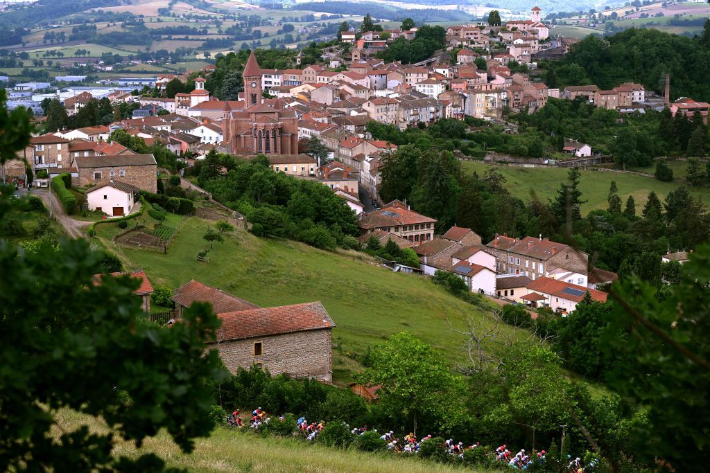 CHAINTRE FRANCE JUNE 09 A general view of the peloton compete passing through Thizy les Bourgs village landscape at start during the 74th Criterium du Dauphine 2022 Stage 5 a 1623km stage from ThizylesBourgs to Chaintr WorldTour Dauphin on June 09 2022 in Chaintre France Photo by Dario BelingheriGetty Images