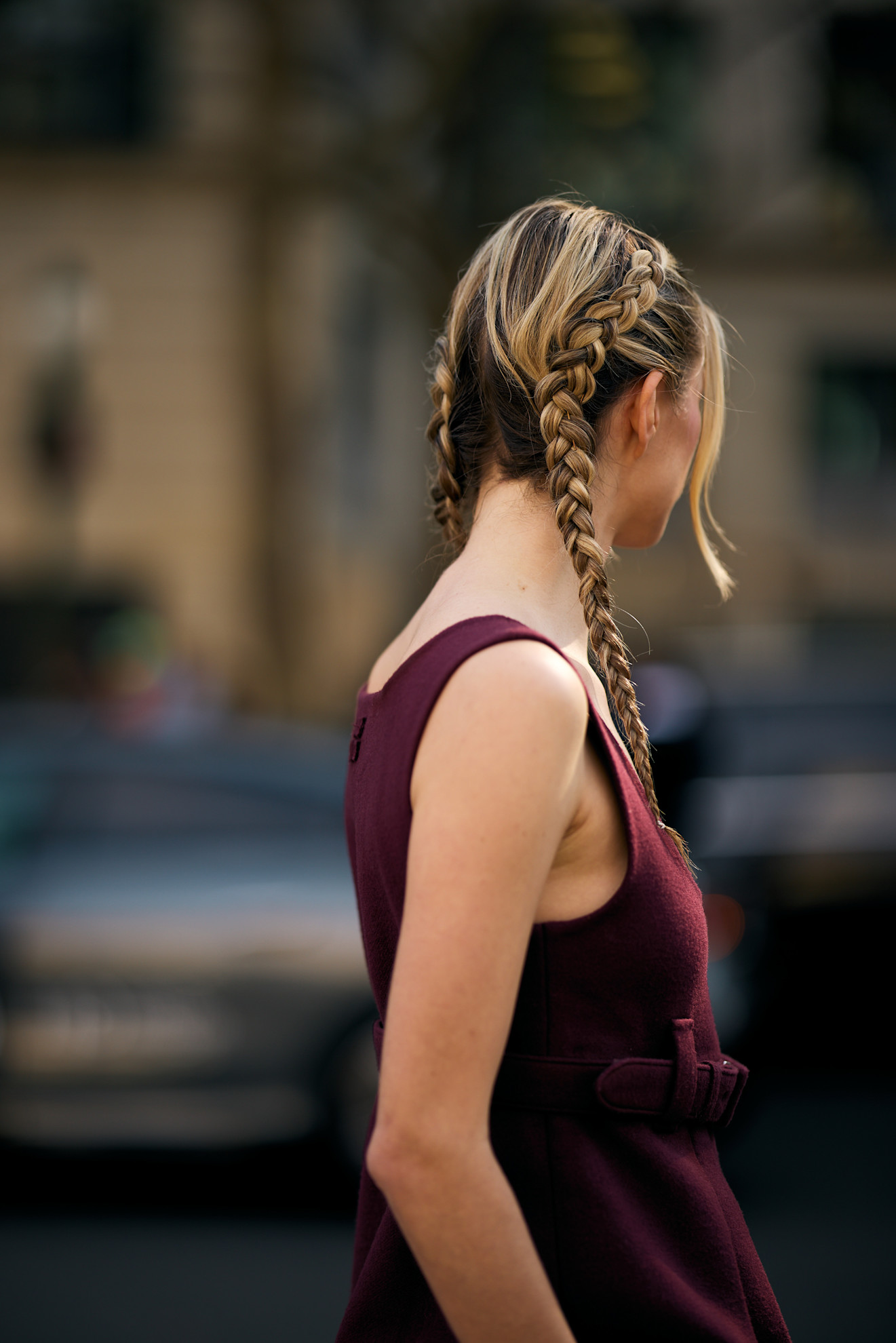 the back of a blonde woman's head with braided pigtails in a red dress