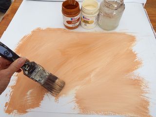 Photo of artist applying a tan-coloured primer