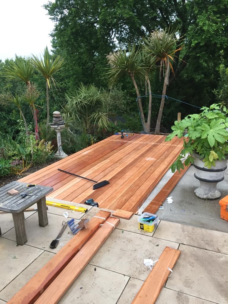 Decking being laid in a garden by a water fountain