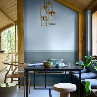 room with blue wall hanging light and wooden chair