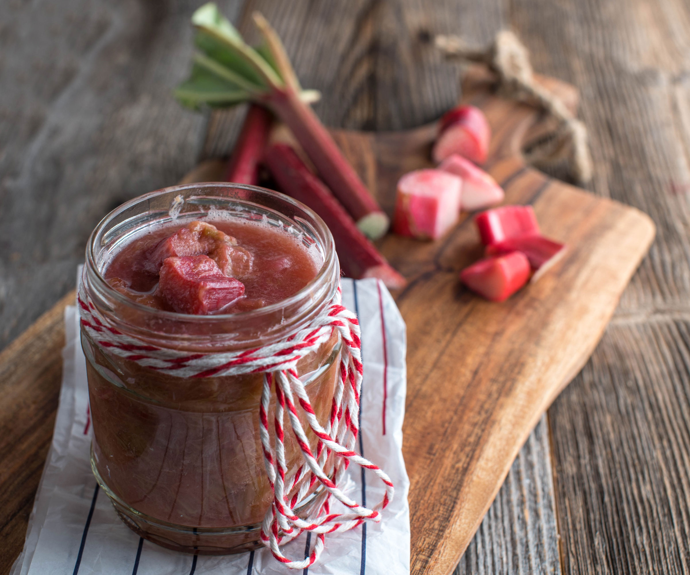 rhubarb chopped up near glass jar of rhubarb preserve