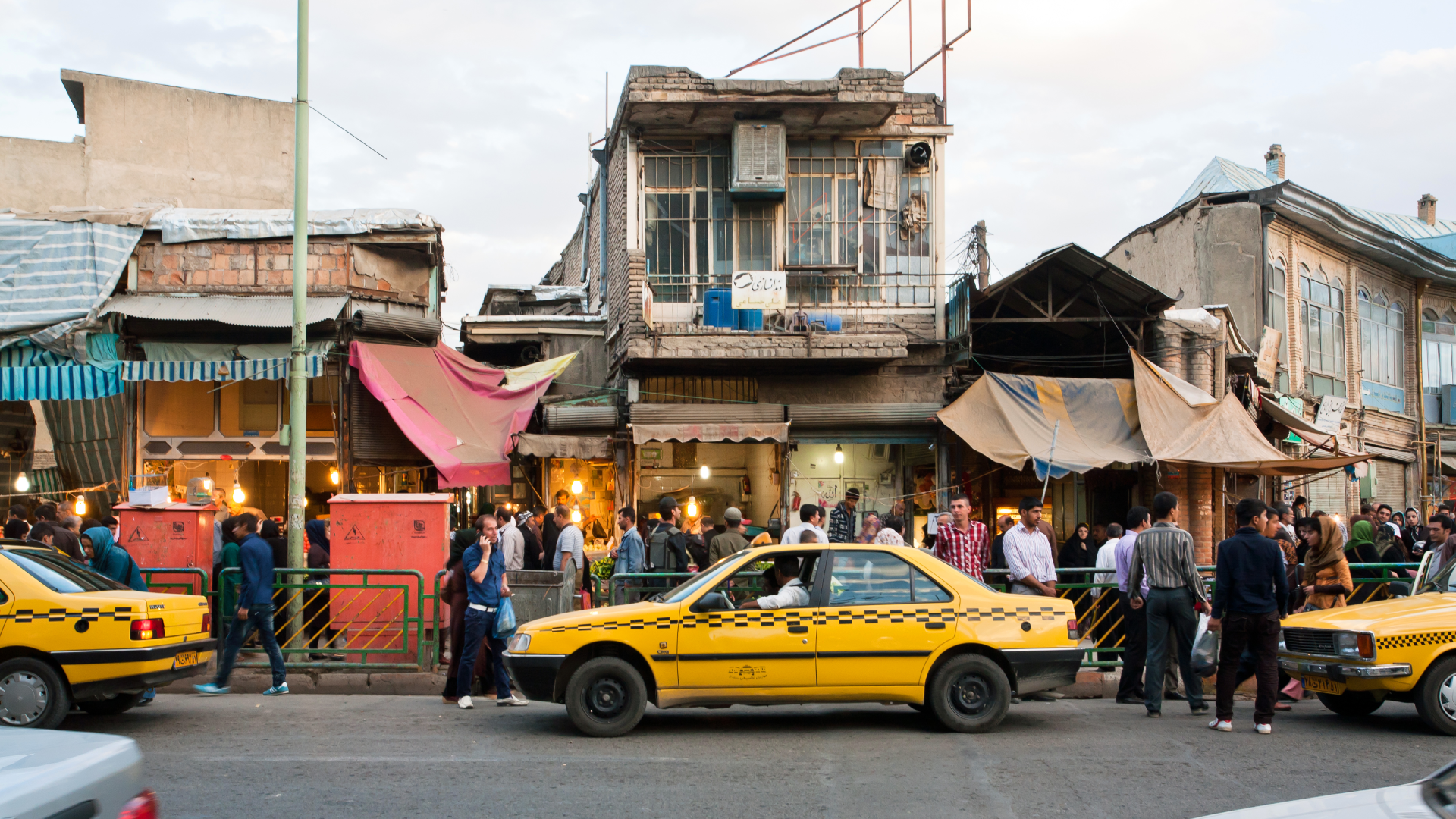 Sanandaj, Iran - October 9, 2014: People walk around street market with line of taxi cars of yellow color on October 9, 2014. capital of Kurdish culture &amp;amp; Kurdistan Province, Sanandaj has population of 380,000