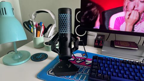 The Asus Rog Carnyx on a desk alongside a colorful mouse mat and keyboard.