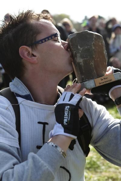 A fan on the Kwaremont kisses a pieve of the famed Muur
