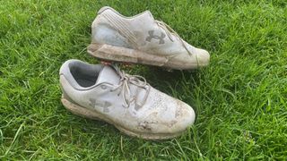 An old golf shoe with lots of signs of wear and tear