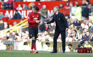 Ole Gunnar Solskjaer, right, passes a note to Marcos Rojo