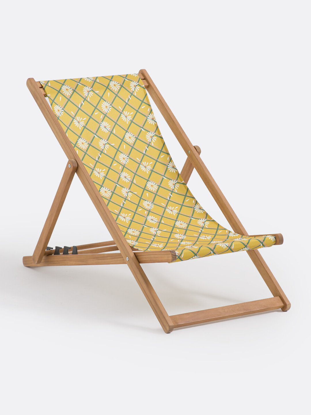 A deck chair with yellow floral patterned fabric