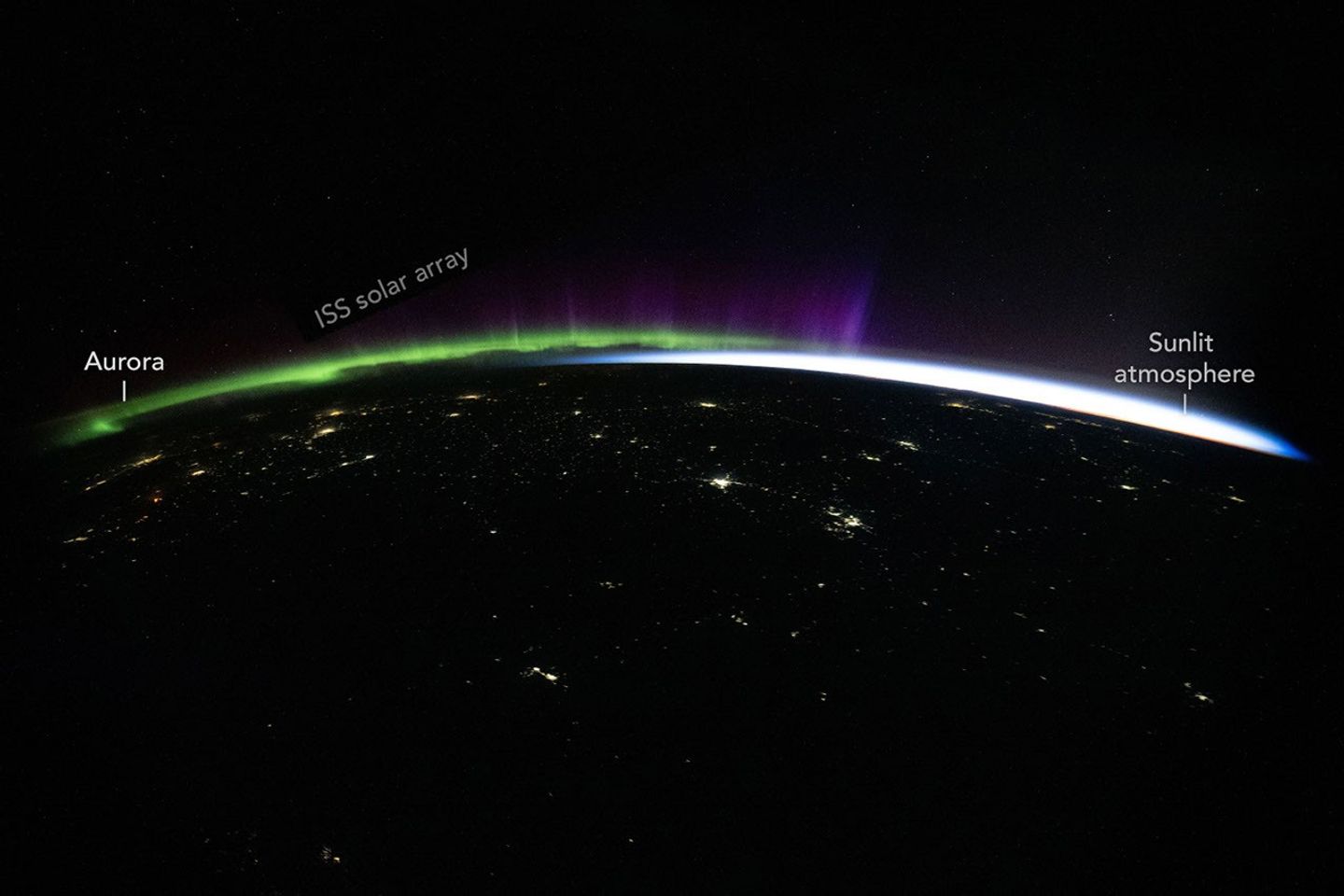 NASA image of green and purple aurora tracing curvature of the Earth from ISS by Jessica Meir