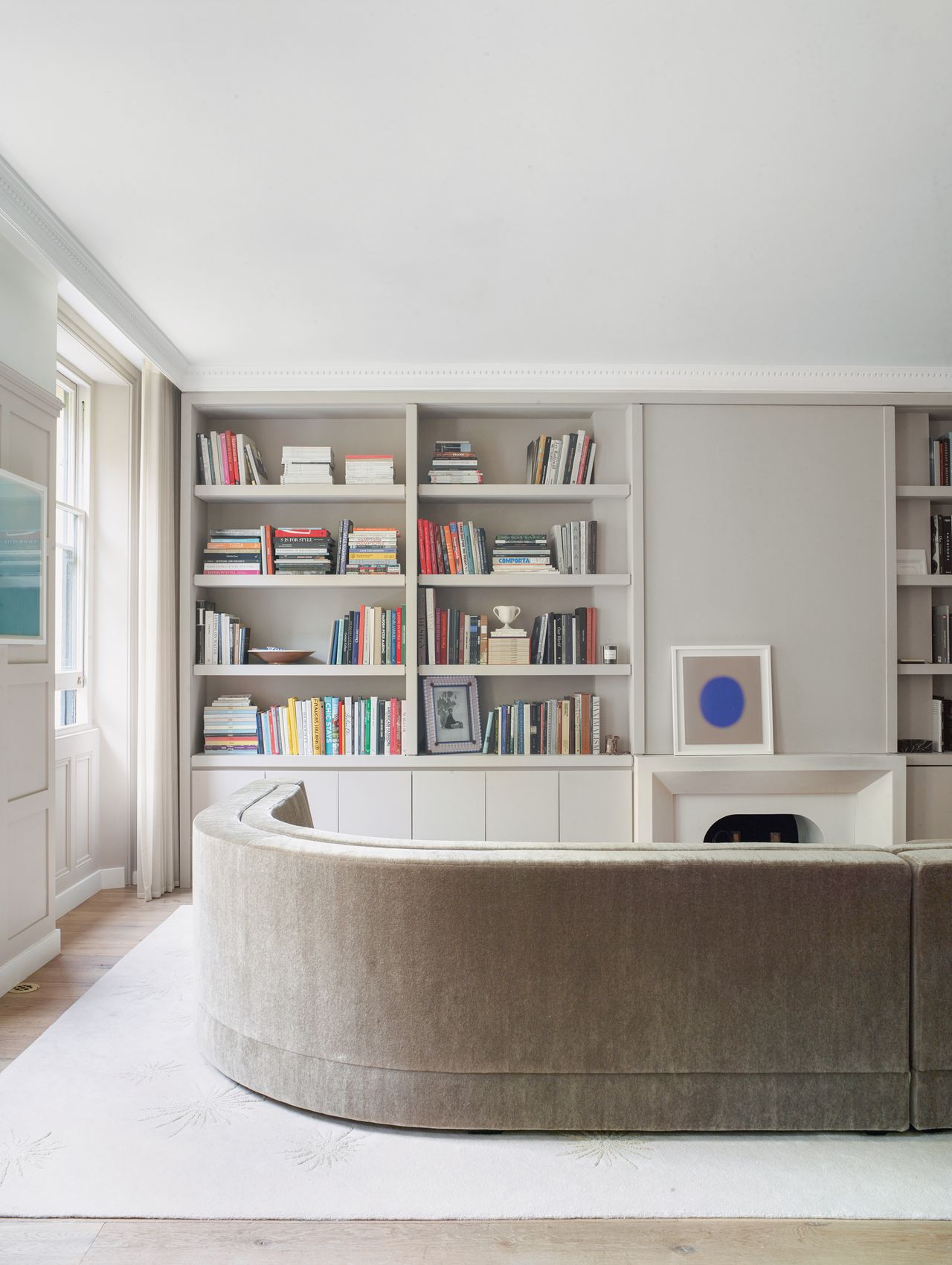 a grey living room with books on a shelf