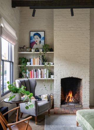 Modern living room with exposed brick wall painted white and fireplace