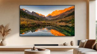 The 115-inch Samsung QN90F Neo QLED TV in a beige living room.