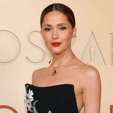 Rose Byrne wears red lipstick on the Oscars red carpet. 