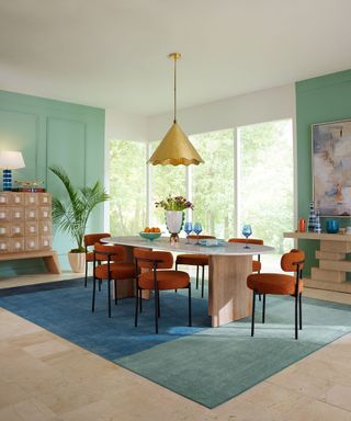 dining room with blue and green rug and mid-century modern table and chairs