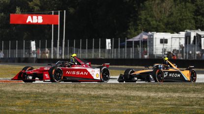 Two cars battling through a corner at a Formula E event