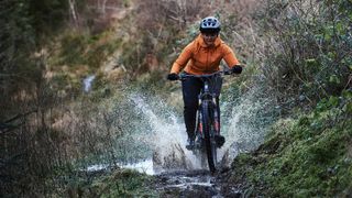 Mountain biker riding through puddle