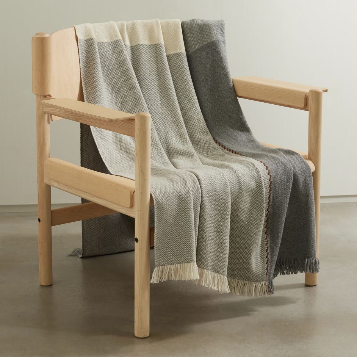 A grey blanket slung over a wooden chair