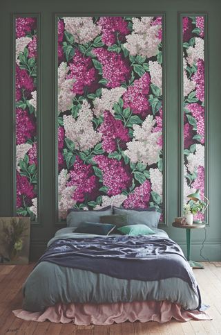 Big pink floral wallpapered panelling in bedroom with green walls and bedding