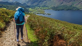 Woman hiking with poles along a trail from Walla Crag in the Lake District of Cumbria, England