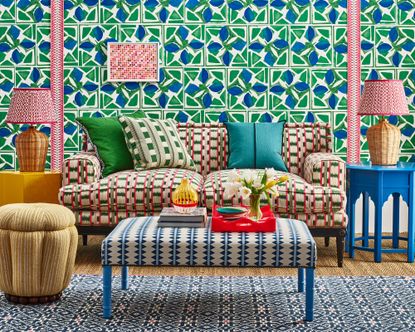 colourful living room with patterned wallpaper, sofa and ottoman