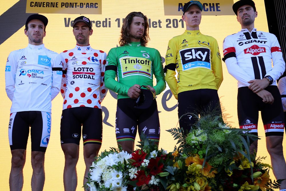 The jersey wearers take part in a solemn podium ceremony following stage 13.