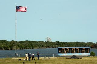 Marine One, a helicopter carrying President Barack Obama and his family, flies near the space shuttle Endeavour and NASA's Launch Pad 39A during a visit on April 29, 2011 following a launch delay for the shuttle's final mission. Another helicopter is acco
