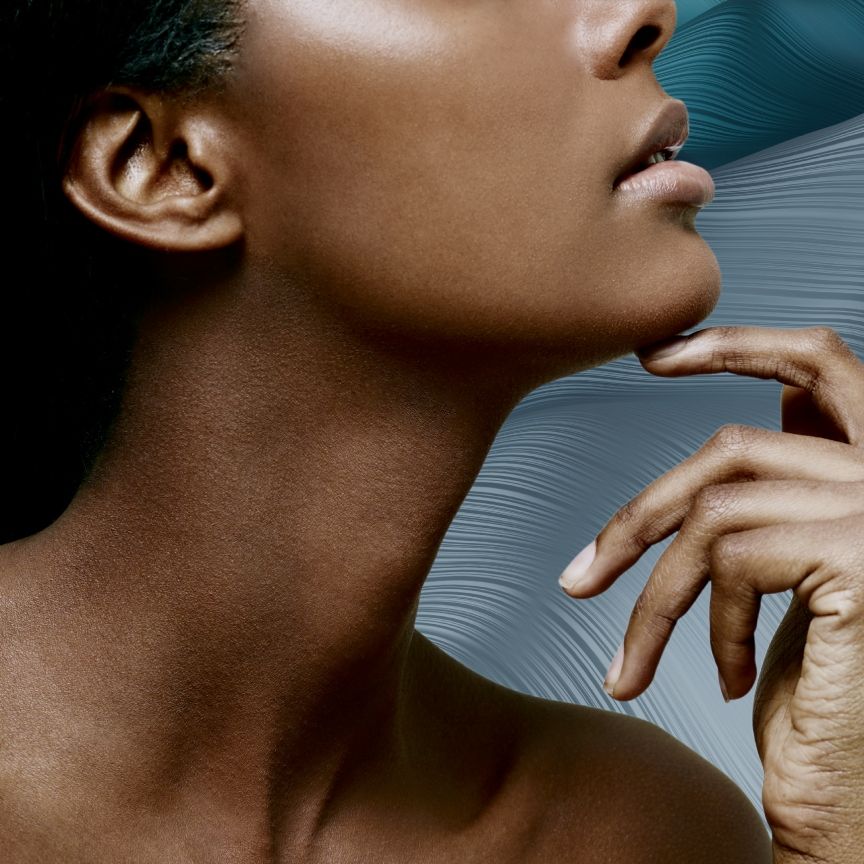a profile of a woman's neck and chin on a blue backdrop