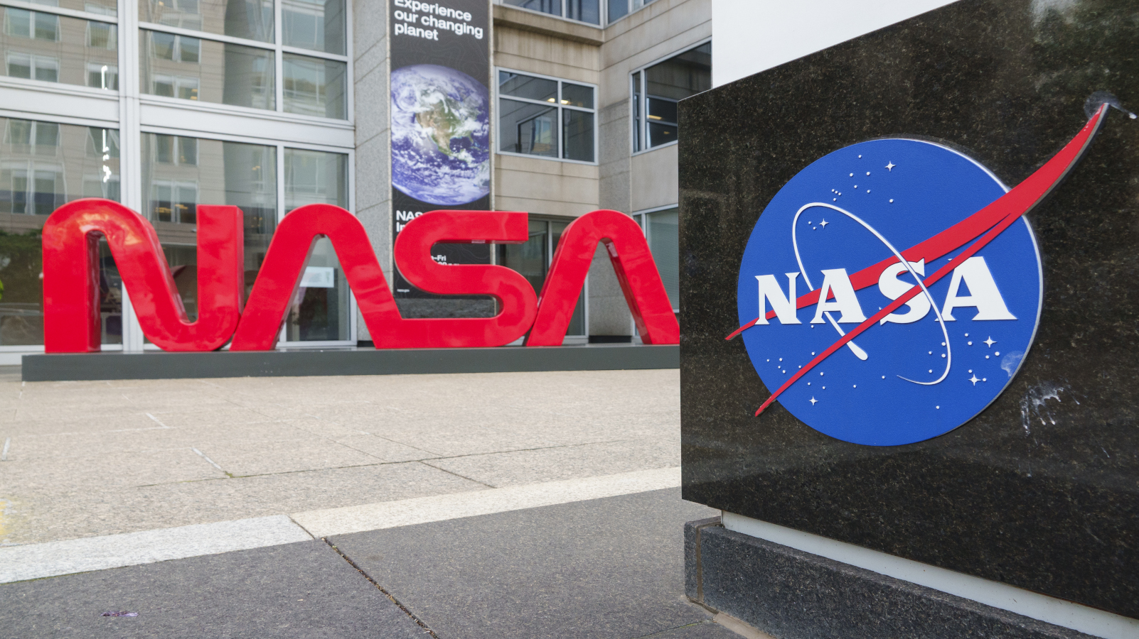 Large red letters spelling out NASA as a logo with a blue NASA icon nearby at the agency&#039;s headquarters.