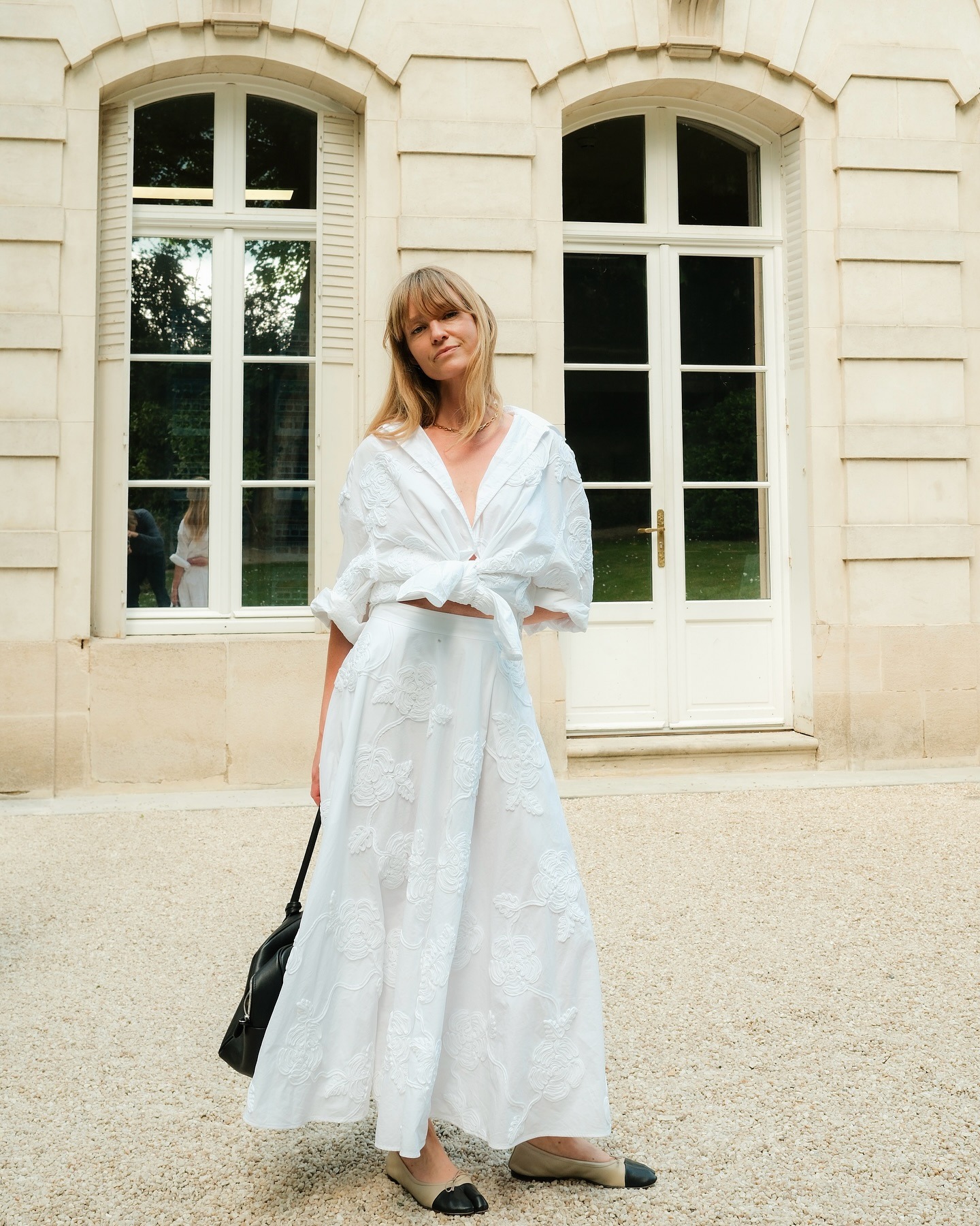 Influencer wearing a white button-down and long white skirt
