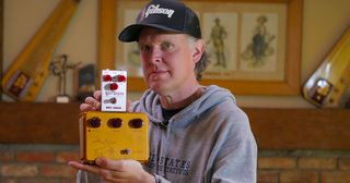 Joe Bonamassa holding a Way Huge Deep State pedal and a Klon