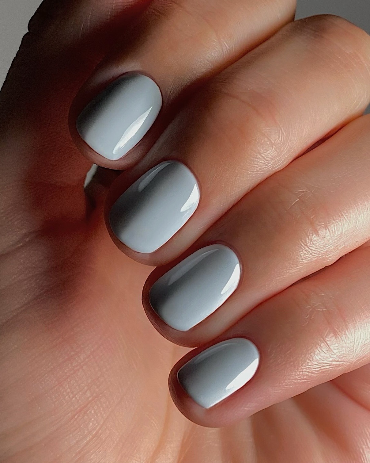 A close-up of a powder blue manicure