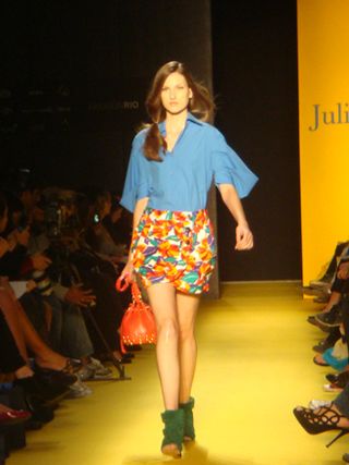 Model wearing a blue shirt and multicoloured skirt