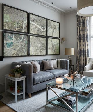 A small living room with a grey scheme and map prints on the wall above the sofa.