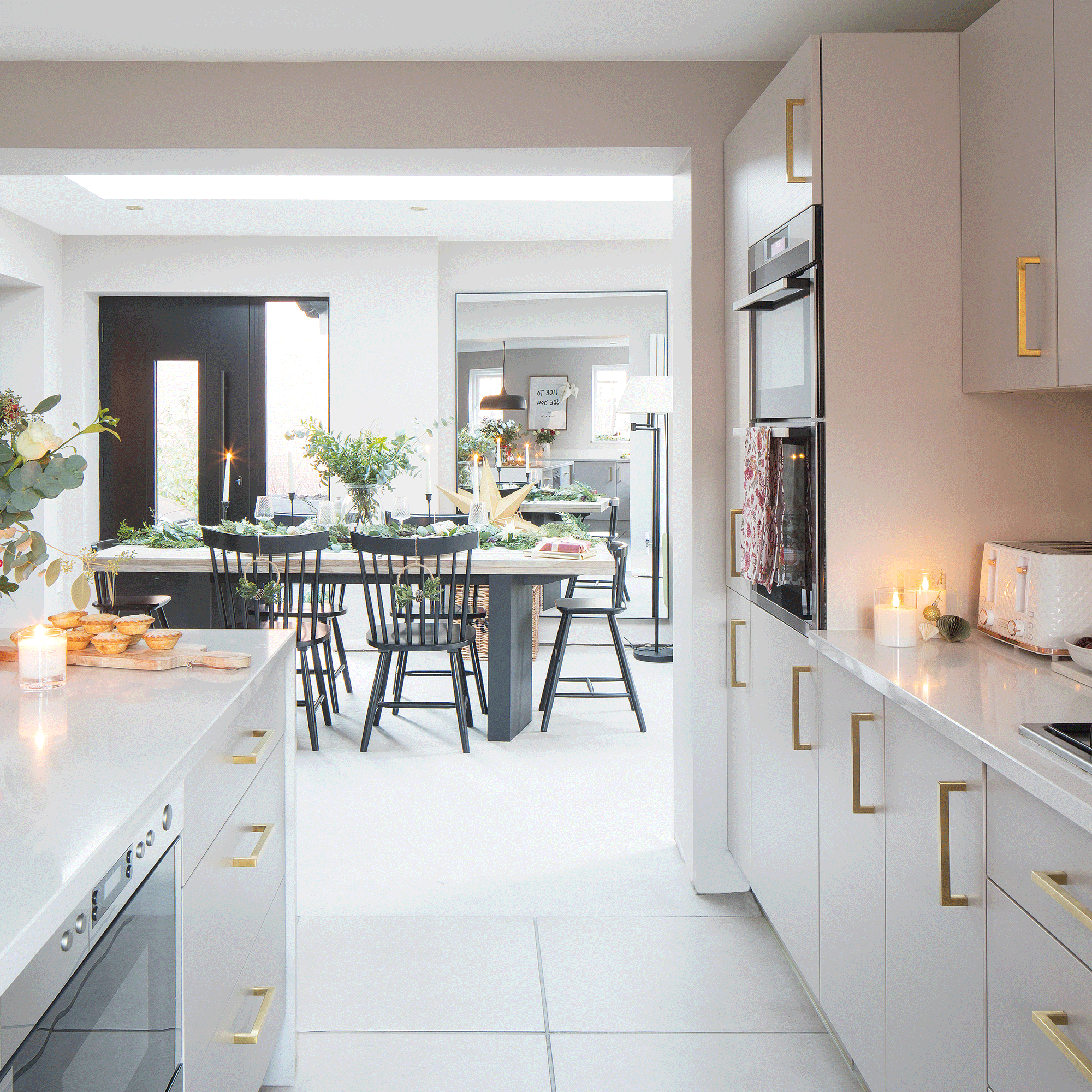 a white contemporary kitchen with a view into an open-plan dining area