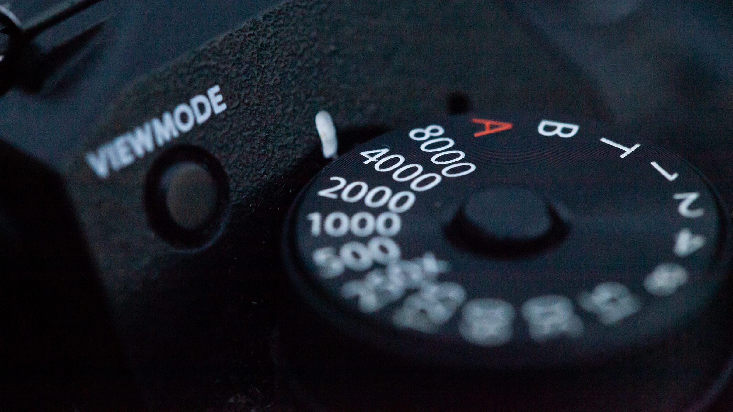 Close-up of a camera dial featuring various shutter speed settings, labeled from 500 to 8000, and a "VIEWMODE" indicator