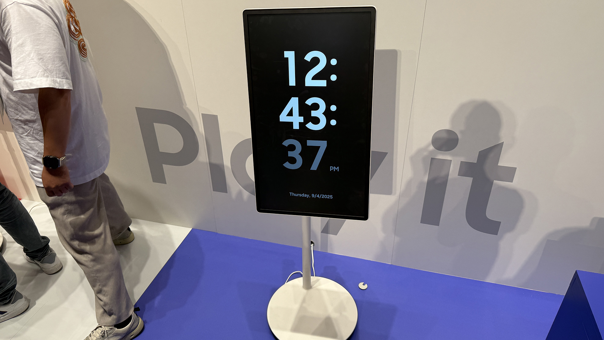 Samsung's The Movingstyle TV on its stand in portrait mode, showing the time on the screen