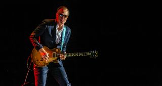 Joe Bonamassa in full stage wear of suit and shade plays a 1959 Gibson Les Paul Standard onstage in Birmingham.