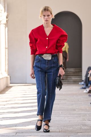 model wearing a red shirt and straight-leg jeans on the Bally Spring 2025 runway