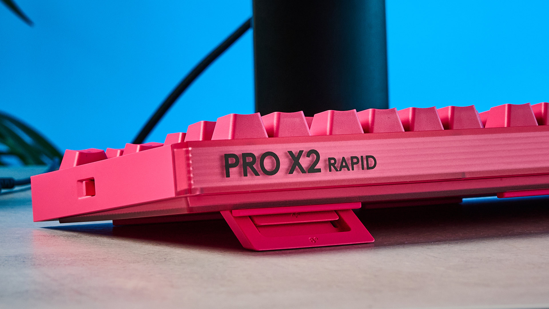 A photo of the Logitech G Pro X2 Rapid keyboard in hot pink on a stone surface