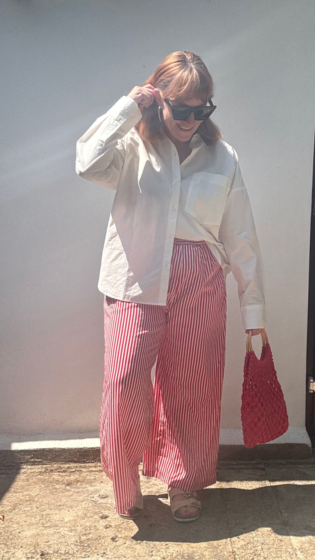 Matilda wearing a white shirt with striped trousers