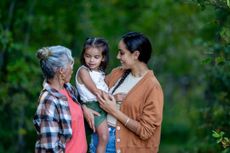 Three generations of women stand together.