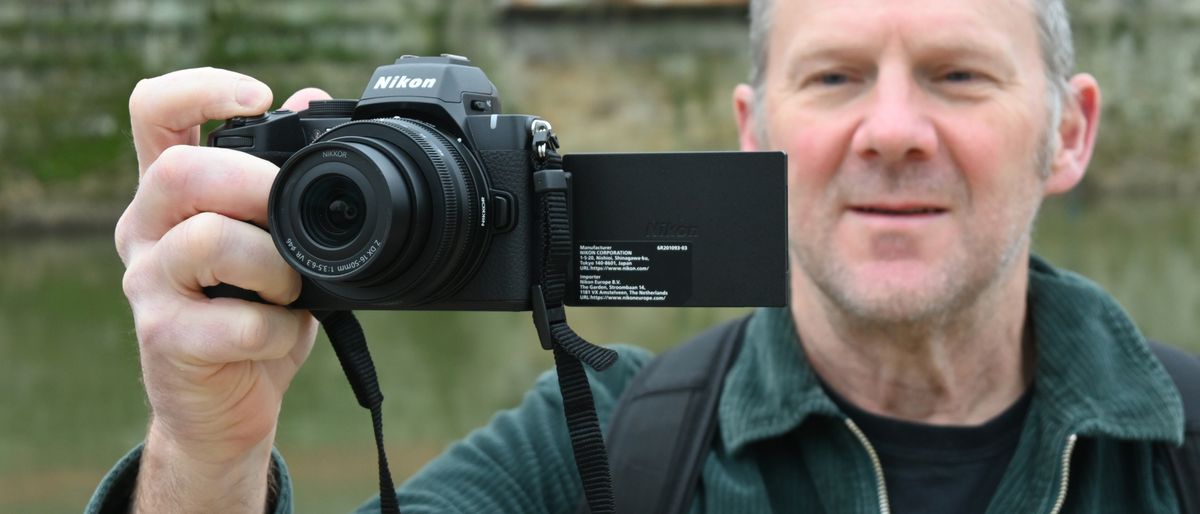 Man looking at Nikon Z50 II rear screen