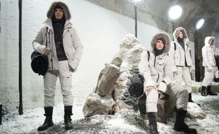 Four men in white puffer coats and trousers