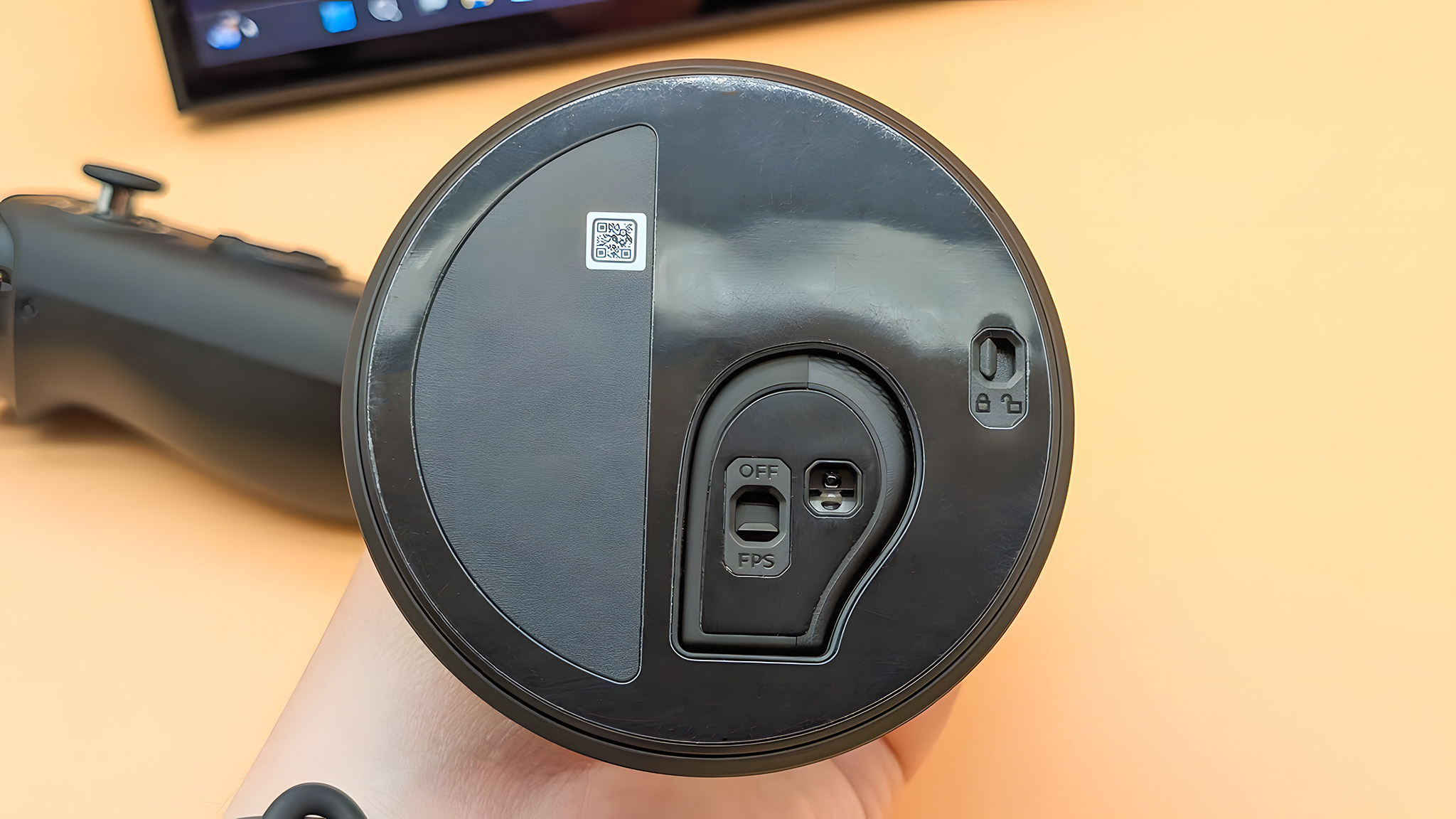 The underside of the FPS mode base with the right Lenovo Legion Go 2 controller locked into it. There is a switch for releasing the controller and another switch for turning FPS mode on and off. 