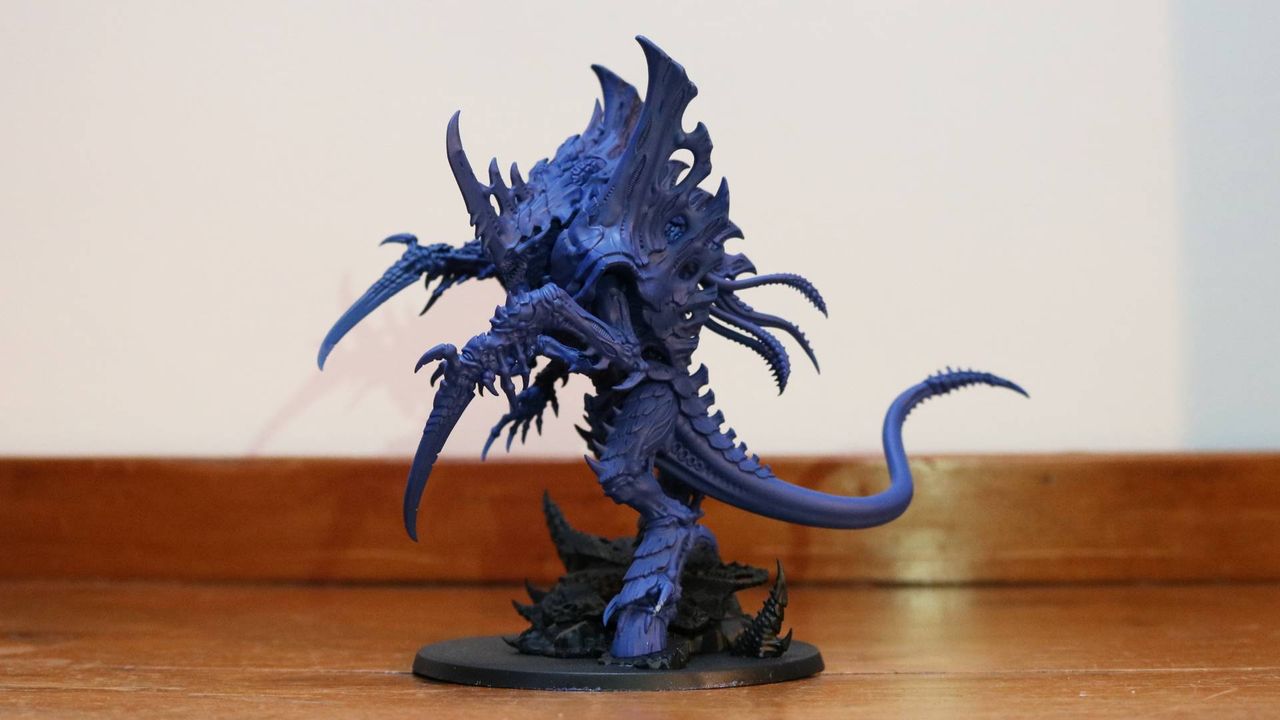 Tyranid Norn Emissary model on a wooden table